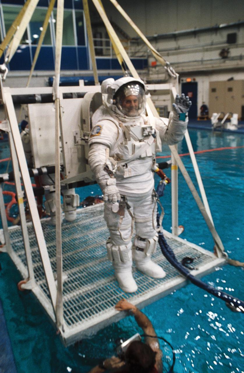 S93-31702 (3 April 1993) --- Astronaut David A. Wolf participates in training for contingency extravehicular activity (EVA) for the STS-58 mission.  Behind Wolf, sharing the platform with him is astronaut Shannon W. Lucid.  For simulation purposes, the two mission specialists were about to be submerged to a point of neutral buoyancy in the Johnson Space Center's (JSC) Weightless Environment Training Facility (WET-F).  Though the Spacelab Life Sciences (SLS-2) mission does not include a planned EVA, all crews designate members to learn proper procedures to perform outside the spacecraft in the event of failure of remote means to accomplish those tasks.