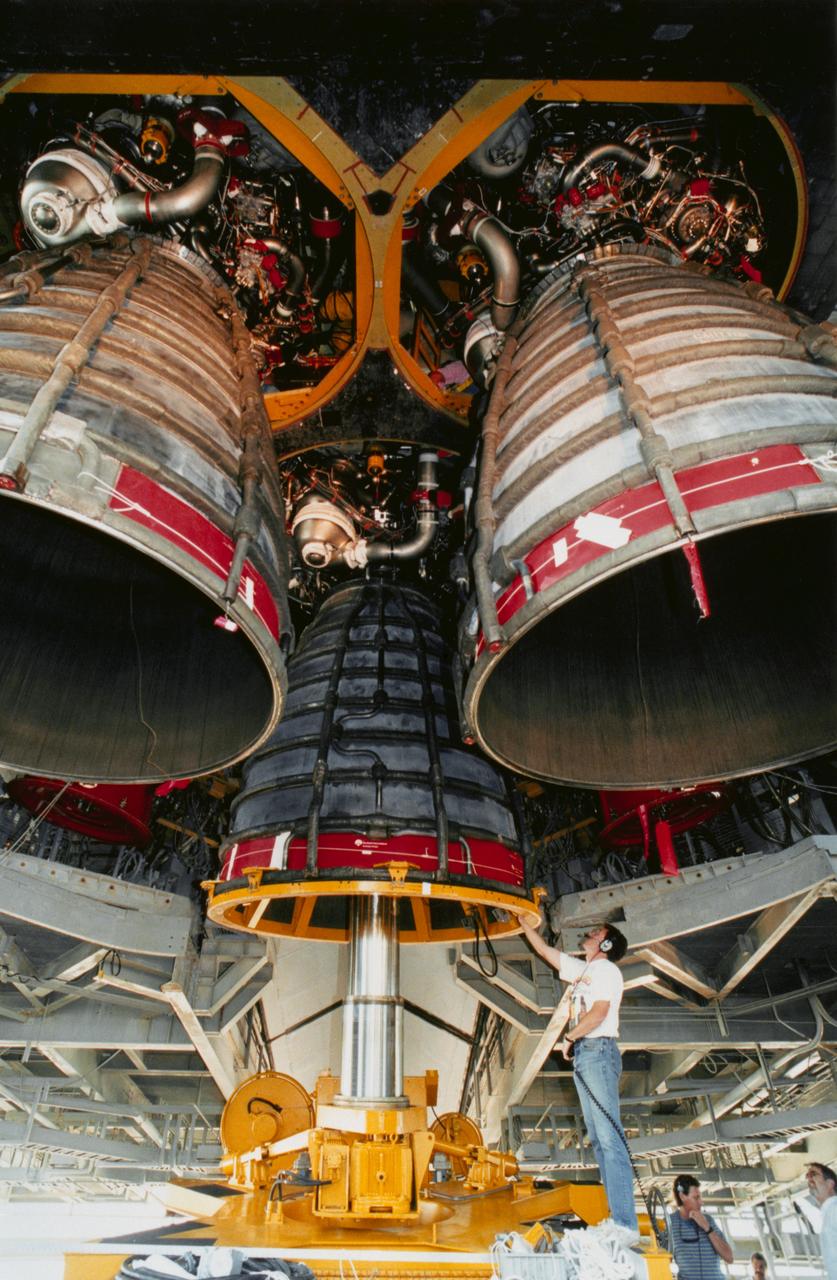 S93-43619 (18 Aug 1993) --- At Launch Pad 39B, work is under way to remove and replace the three main engines on the Space Shuttle Discovery.  Here, Rocketdyne workers Jim Tibble (left), John Mooney and Ken Bair are assisting with the removal of the first engine, main engine no. 1, using the engine vertical installer.  A failed sensor in main engine no. 2 led to the shutdown of all three engines three seconds before liftoff of mission STS-51 on August 12, 1993.  Because it is difficult to perform the necessary inspections, refurbishment, and retesting of a fired engine on a vehicle at the pad, NASA opted to install a fresh set of engines on Discovery.