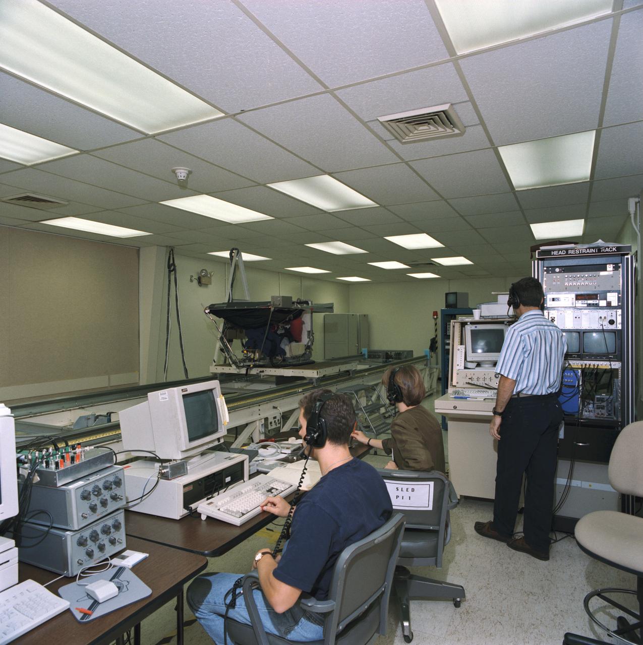 S93-45365 (29 Sept 1993) --- Payload specialist Martin J. Fettman, in an oscillating sled device in upper left, participates in a data collection project for neurovestibular functions.  His responses to the sled's movements are recorded by a team of monitors in the foreground.  The seven Spacelab Life Sciences (SLS-2) crew members devoted a full day to miscellaneous biomedical data collection in preparation for next month's two week mission aboard Columbia.