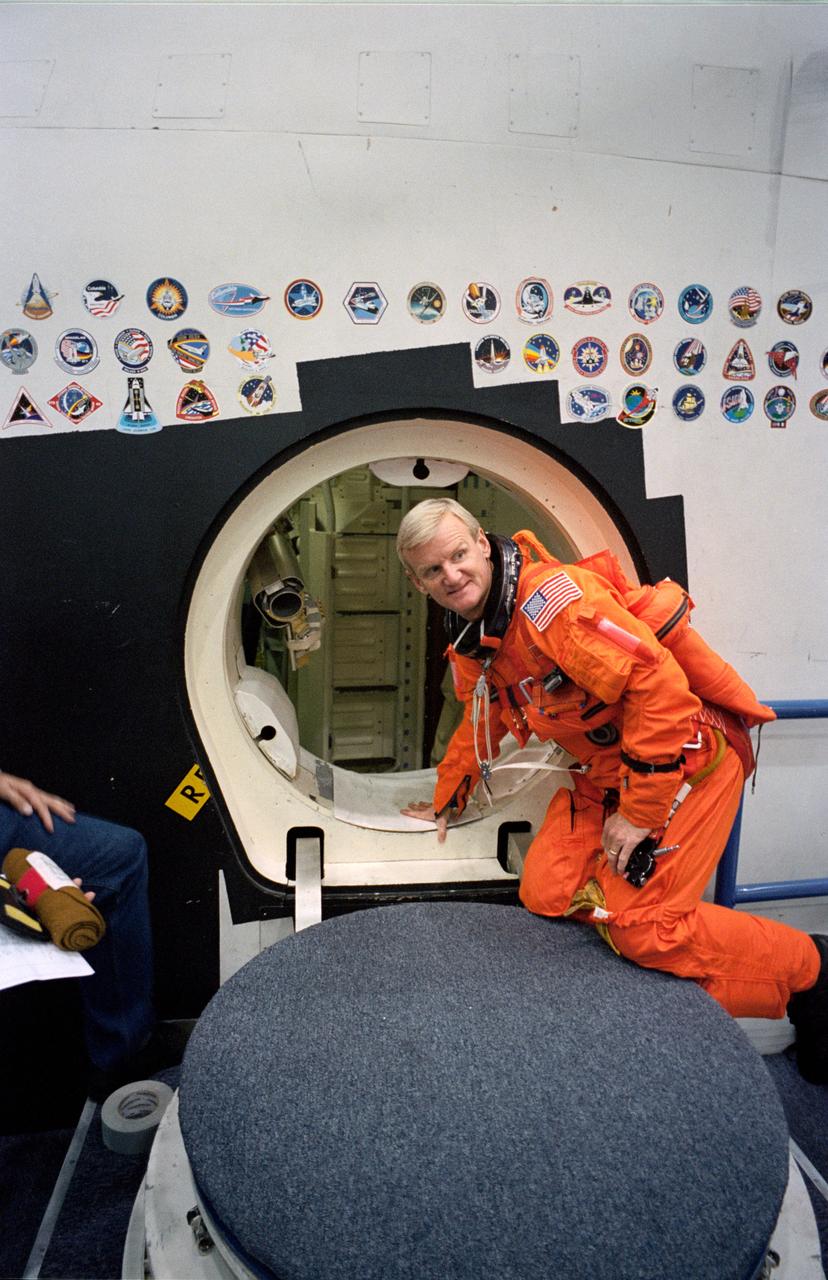 S93-48461 (5 Nov. 1993) --- In the Johnson Space Center's (JSC) Shuttle mockup and integration laboratory, astronaut John H. Casper simulates an emergency ejection from the space shuttle.  Barely visible in the hatchway of the Shuttle crew compartment trainer (CCT) is the escape pole device like that flown on each shuttle flight.  Casper and four other NASA astronauts will spend two weeks in space aboard the Space Shuttle Columbia in March 1994.