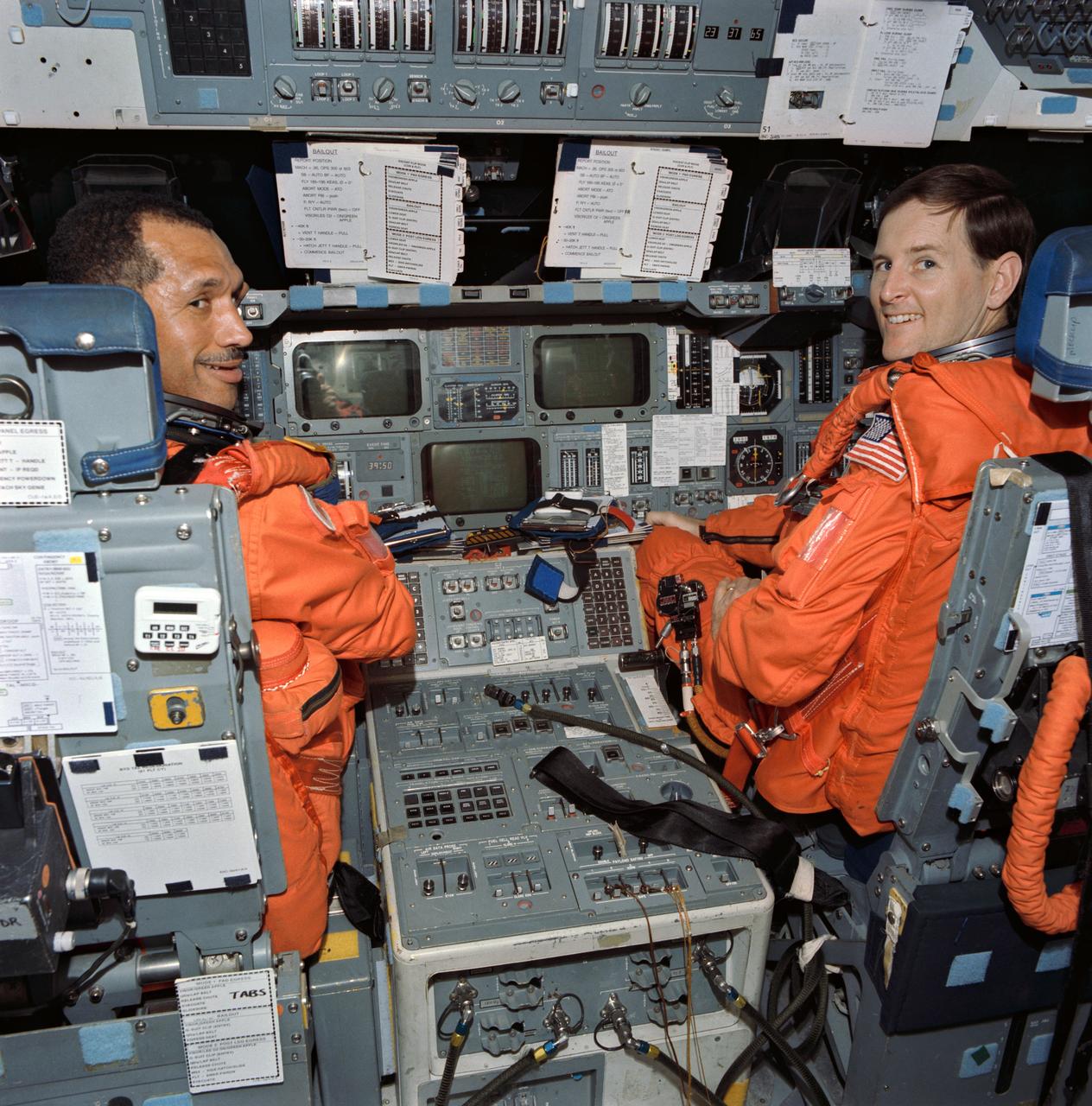 Astronauts Charles F. Bolden Jr. (left) and Kenneth S. Reightler, commander and pilot, respectively, for the STS-60 mission, rehearse some of their duties on the flight deck of the crew compartment trainer in JSC's Shuttle mockup and integration laboratory (50652); Astronaut N. Jan Davis, mission specialist for STS-60, gets assistance with her suit from Lockheed's Max Kandler during a training session at JSC's Shuttle mockup and integration laboratory. She is seated in the mission specialist station on the middeck mockup (50653).