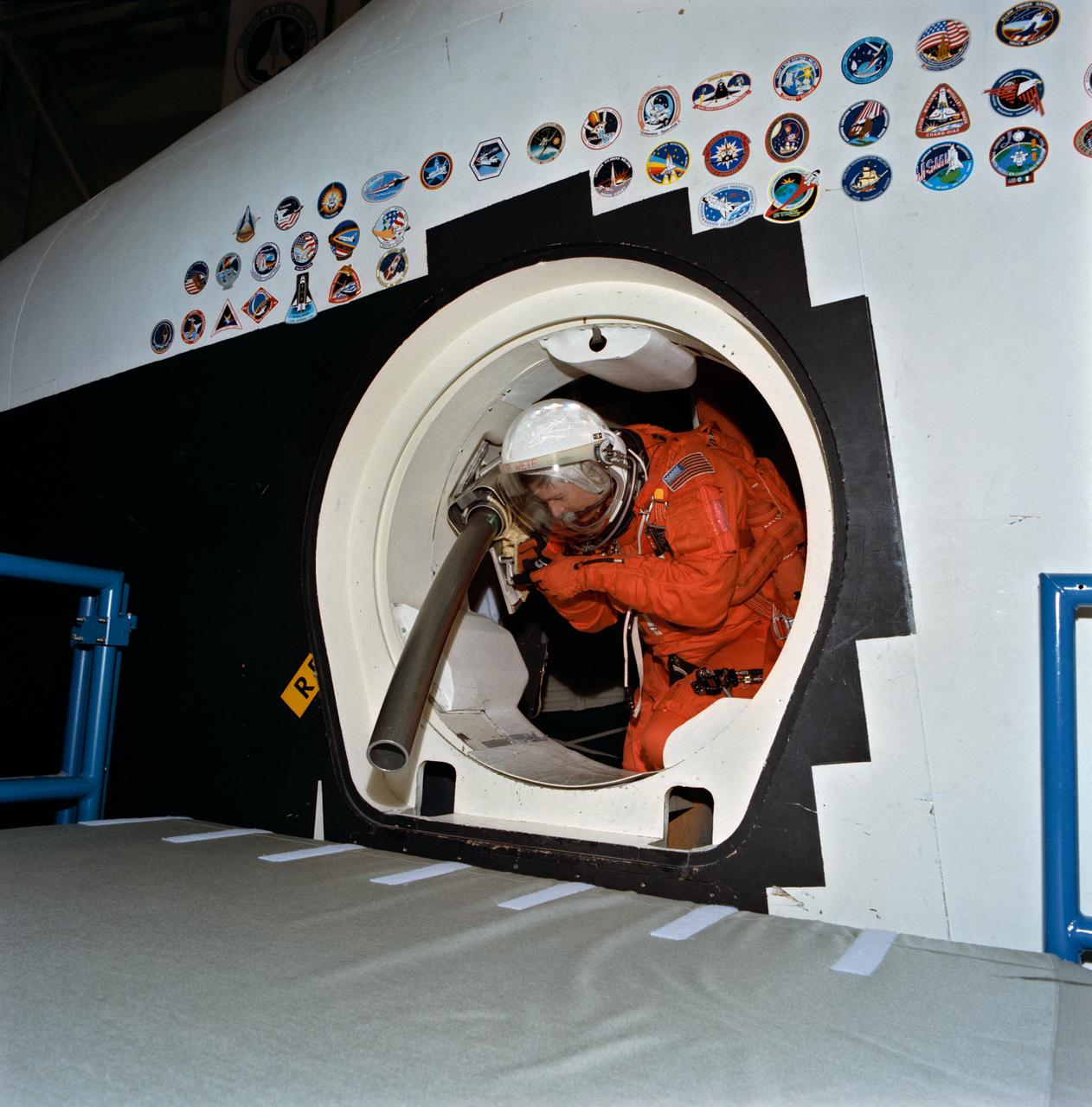 Astronaut Kenneth S. Reightler, pilot for the STS-60 mission, prepares to simulate egress from a troubled Space Shuttle using Crew Escape System (CES) pole. The action came during emergency egress training in JSC's Shuttle mockup and integration laboratory.