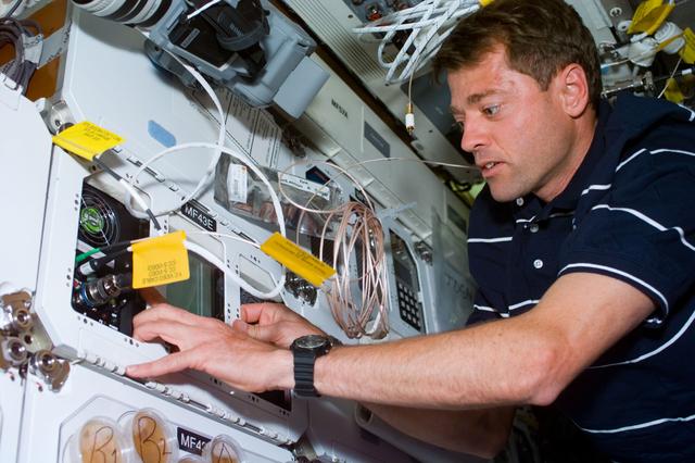 NASA image: STS-93 Pilot Ashby works with the CGBA experiment on the middeck