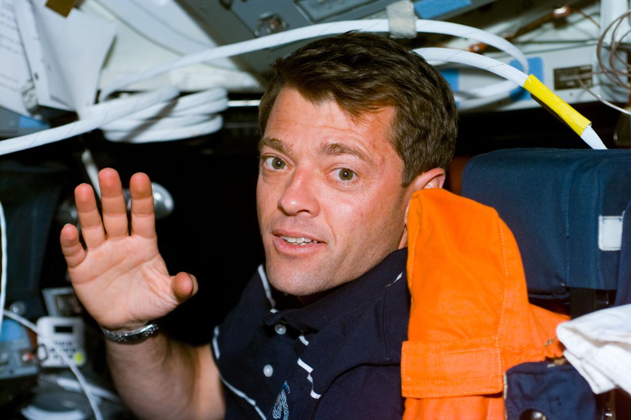S93-E-5029 (23 July 1999) --- Astronaut Jeffrey S. Ashby waves to the camera from the pilot's station on the starboard side of Columbia's forward flight deck.  The photo was recorded with an electronic still camera (ESC)  on Flight Day 1 of the STS-93 mission.