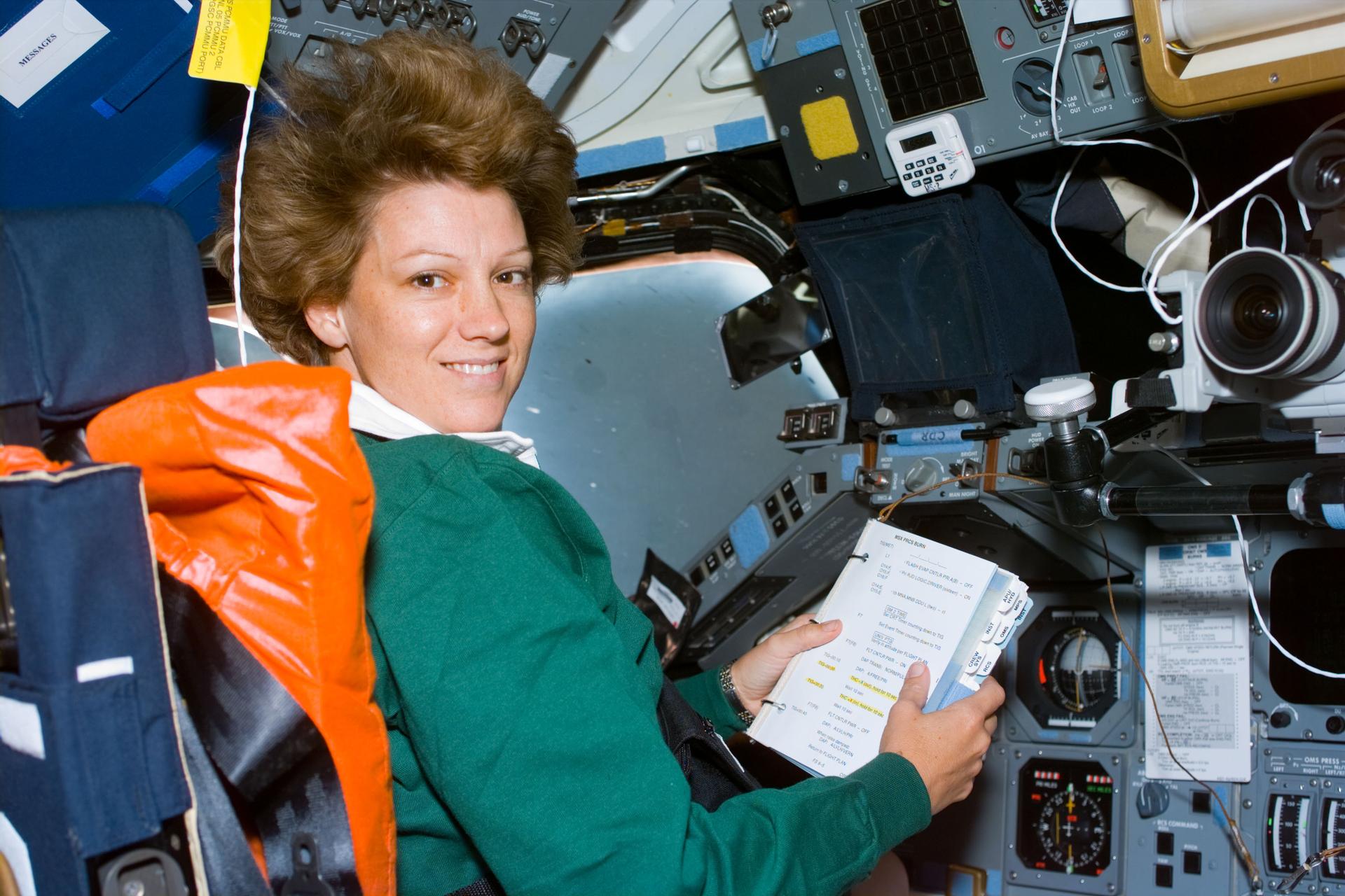 Commander Collins with a checklist in space shuttle Columbia