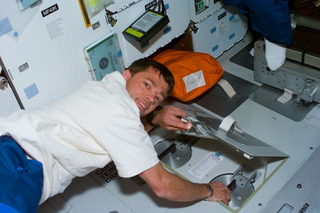 NASA image: Pilot Ashby exchanges the LiOH canisters on the middeck of Columbia