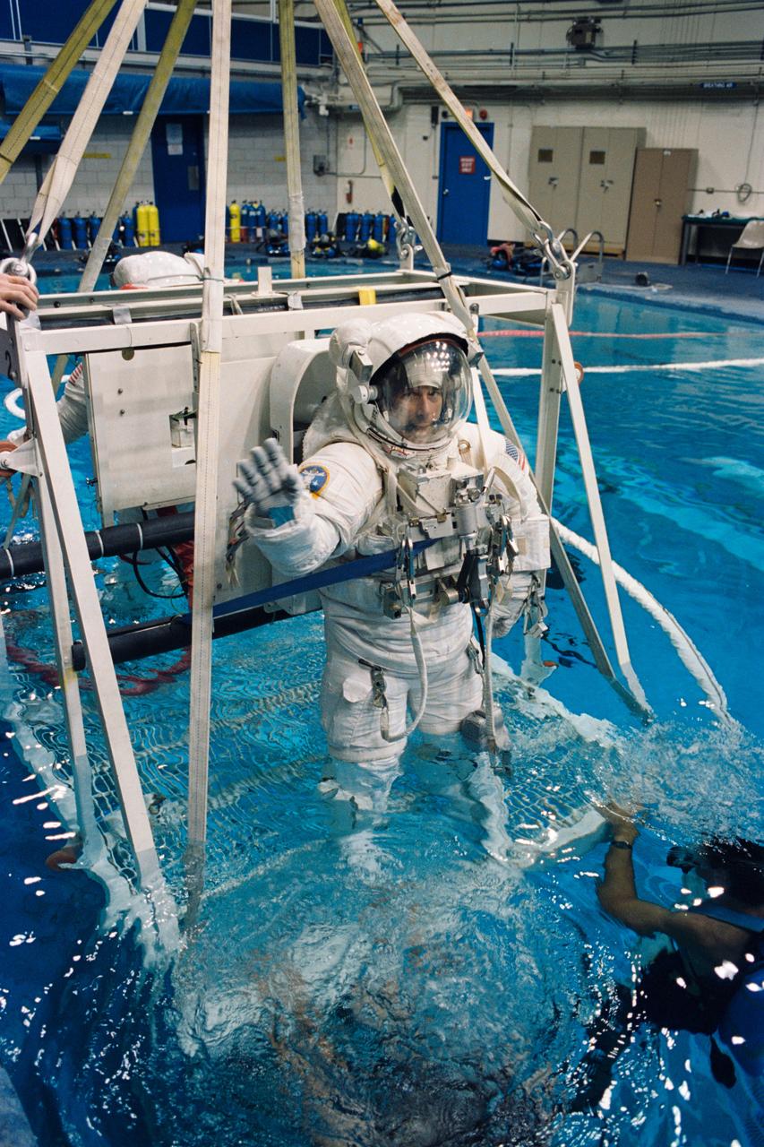 S94-39770 (August 1994) --- Astronaut Carl J. Meade, STS-64 mission specialist, is being submerged prior to an underwater simulation of a spacewalk scheduled for his September mission. Meade, who shared the rehearsal in the Johnson Space Center's (JSC) Weightless Environment Training Facility (WET-F) pool with crewmate astronaut Mark C. Lee (partially visible at left), is equipped with a training version of new extravehicular activity (EVA) hardware called the Simplified Aid for EVA Rescue (SAFER) system. Photo credit: NASA or National Aeronautics and Space Administration