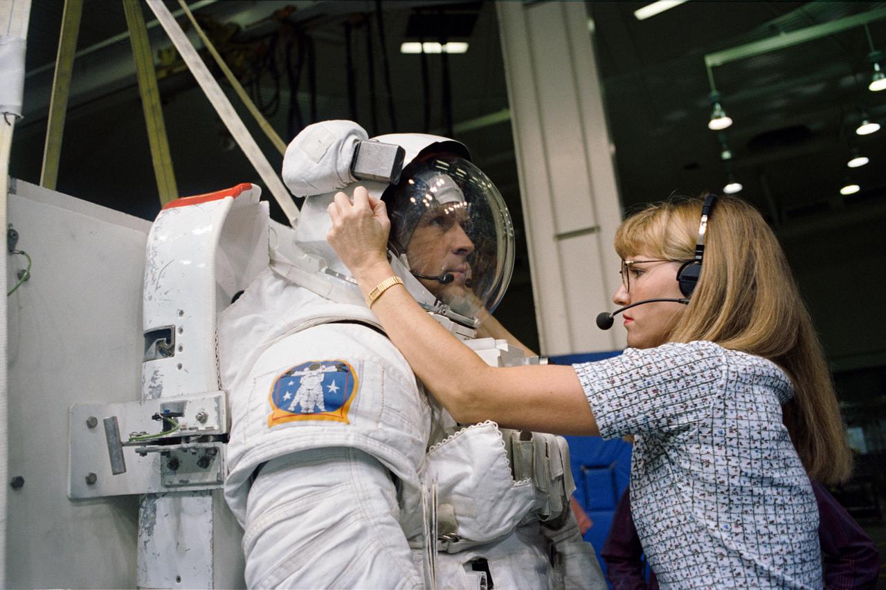 S94-39774 (August 1994) --- Boeing's Kari Rueter checks the helmet of astronaut Mark C. Lee prior to the mission specialist's participation in an underwater rehearsal for an extravehicular activity (EVA). Lee's spacewalk is scheduled for the September STS-64 mission. New rescue gear for use on future space shuttle missions will be evaluated during the mission's single spacewalk, involving astronauts Lee and Carl J. Meade, mission specialists. Photo credit: NASA or National Aeronautics and Space Administration