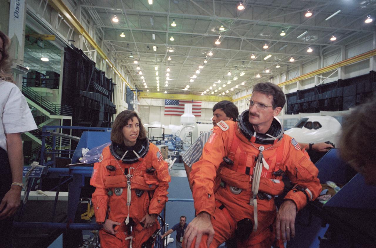 S94-40073 (23 June 1994) --- Wearing training versions of the launch and entry suits (LES), astronauts Ellen Ochoa, payload commander, and Joseph P. Tanner, mission specialist, await the beginning of a training session on emergency egress procedures.  The STS-66 crew participated in the training, held in the Johnson Space Center's (JSC) Shuttle Mockup and Integration Laboratory.  Ochoa and Tanner will join three other NASA astronauts and one international mission specialist aboard the Space Shuttle Atlantis in support of the Atmospheric Laboratory for Applications and Science (ATLAS-3) flight scheduled for November of this year.