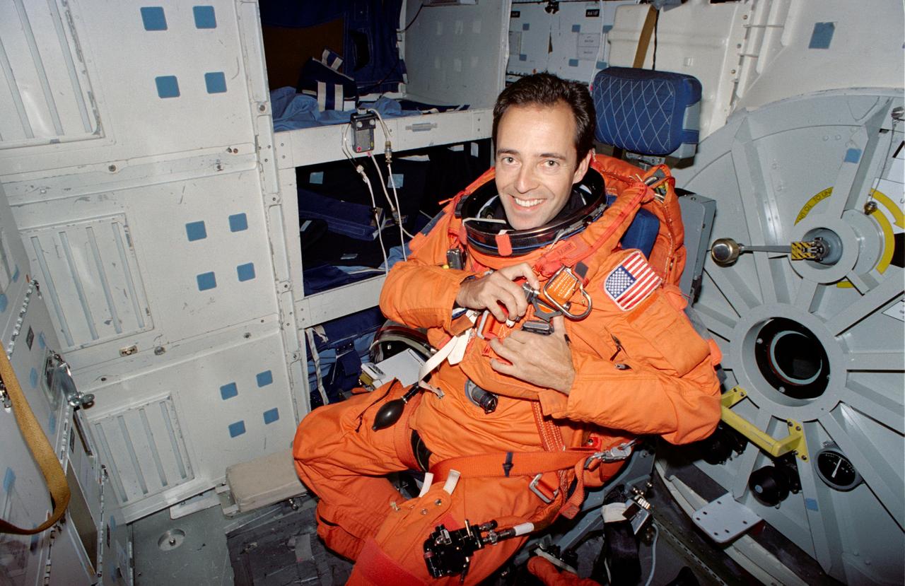 S94-40081 (23 June 1994) --- Wearing a training version of a partial pressure suit, Jean-Francois Clervoy, STS-66 international mission specialist, secures himself on a collapsible seat on the middeck of a Shuttle trainer during a rehearsal of procedures to be followed during launch and entry phases of his scheduled November flight.  This rehearsal, held in the Crew Compartment Trainer (CCT) of the Johnson Space Center's (JSC) Shuttle Mockup and Integration Laboratory, was followed by a training session on emergency egress procedures.  Clervoy, a European astronaut, will join five NASA astronauts for a week and a half aboard the Space Shuttle Atlantis in Earth-orbit in support of the Atmospheric Laboratory for Applications and Science (ATLAS-3).