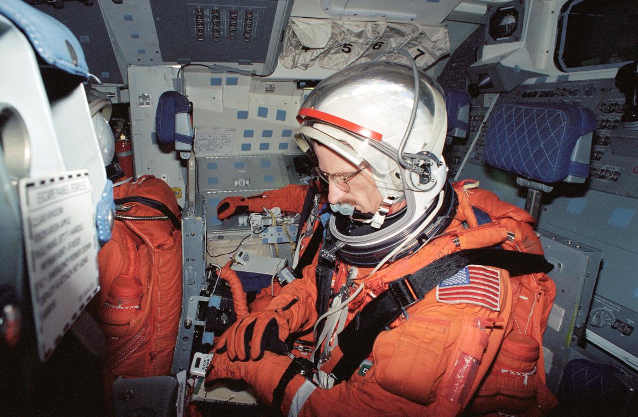 S94-40082 (23 June 1994) --- Astronaut Joseph R. Tanner, mission specialist, checks his glove during a rehearsal for launch and entry phases of the scheduled November flight of STS-66.  This rehearsal, held in the Crew Compartment Trainer (CCT) of the Johnson Space Center's (JSC) Shuttle Mockup and Integration Laboratory, was followed by a training session on emergency egress procedures.  In November, Tanner will join four other NASA astronauts and a European mission specialist for a week and a half aboard the Space Shuttle Atlantis in Earth-orbit in support of the Atmospheric Laboratory for Applications and Science (ATLAS-3).