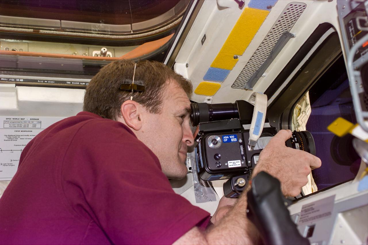 S94-E-5003 (5 July 1997) --- Astronaut James D. Halsell, Jr. , mission commander, positioned on the Space Shuttle Columbia's aft flight deck, takes a picture of the Spacelab Module, several feet away in Columbia's cargo bay.