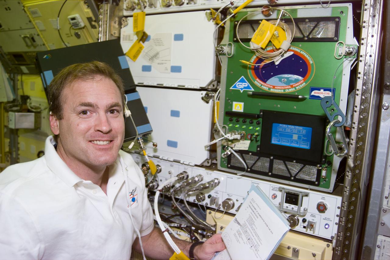S94-E-5021 (6 July 1997) --- Astronaut James D. Halsell, Jr., mission commander, checks on an experiment in the Astro-Planet Generic Bioprocessing Apparatus onboard the Earth-orbiting Space Shuttle Columbia.  The Microgravity Sciences Laboratory (MSL-1) had just completed the first one-third of its manifest time frame.  The image was recorded with an Electronic Still Camera (ESC) and later downlinked to ground controllers in Houston, Texas.