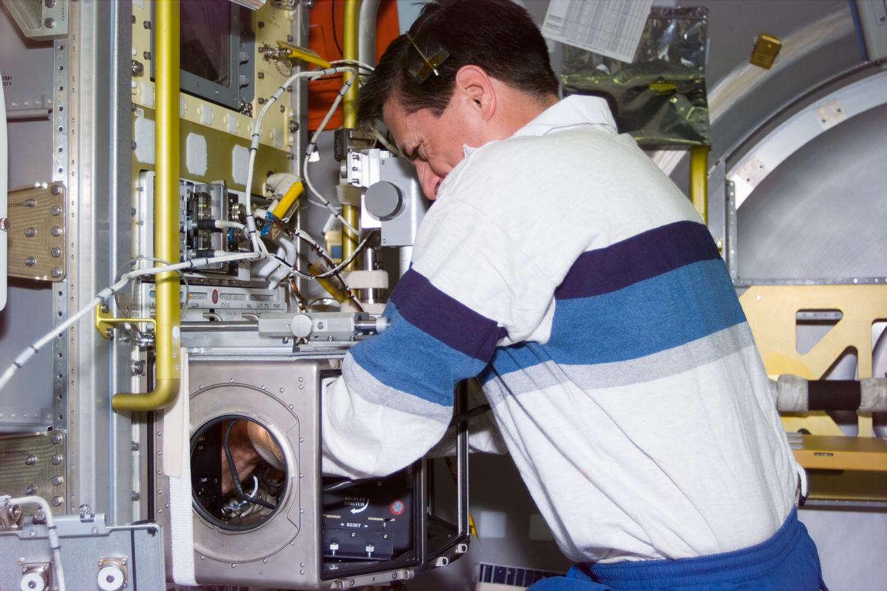 S94-E-5046 (July 1997) --- Astronaut Donald Thomas, mission specialist, sets up an experiment in the glovebox onboard the Spacelab science module.  Thomas joins four other NASA astronauts and two payload specialists who are supporting the Microgravity Science Laboratory (MSL-1) mission aboard the Space Shuttle Columiba.