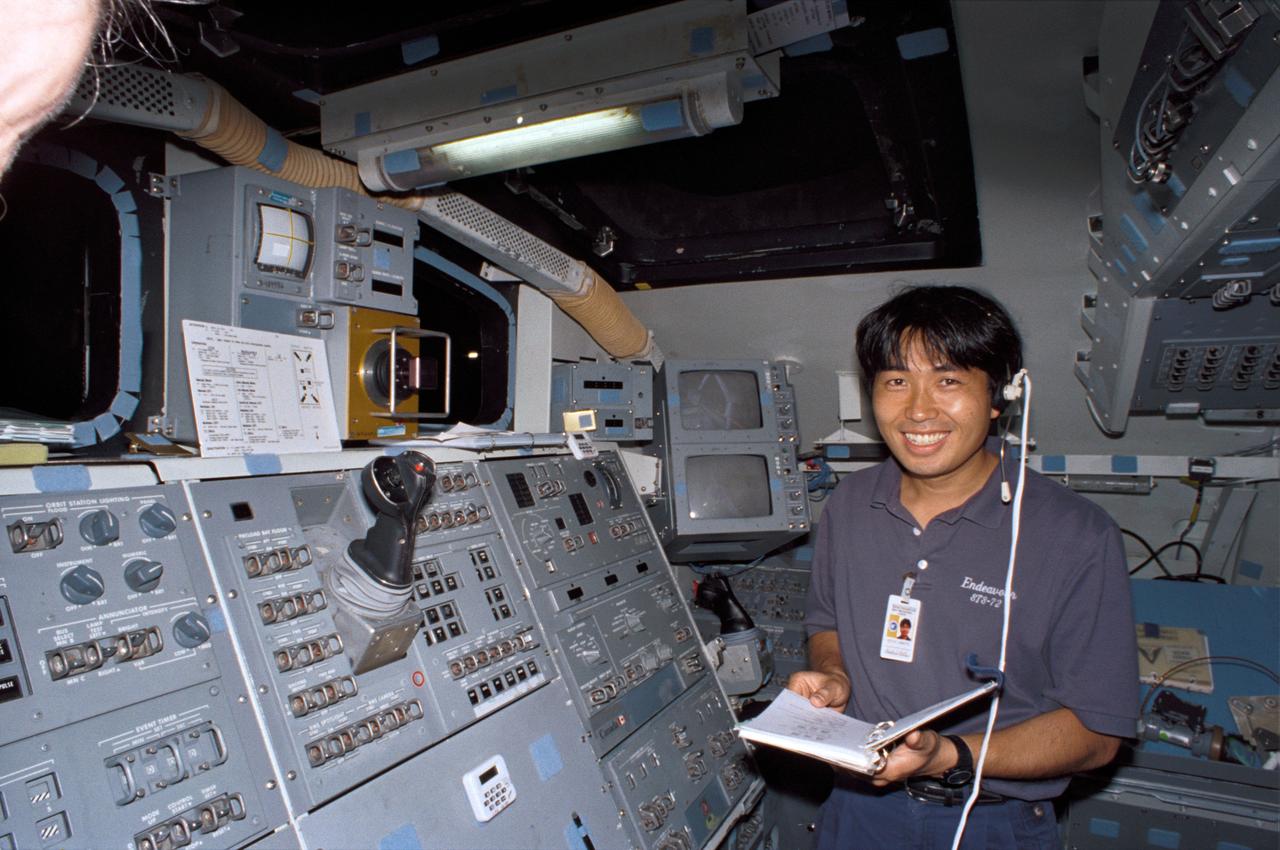 S95-12706 (May 1995) --- Astronaut Koichi Wakata, representing Japan's National Space Development Agency (NASDA) and assigned as mission specialist for the STS-72 mission, checks over a copy of the flight plan.  Wakata is on the flight deck of the fixed base Shuttle Mission Simulator (SMS) at the Johnson Space Center (JSC).  He will join five NASA astronauts aboard Endeavour for a scheduled nine-day mission, now set for the winter of this year.