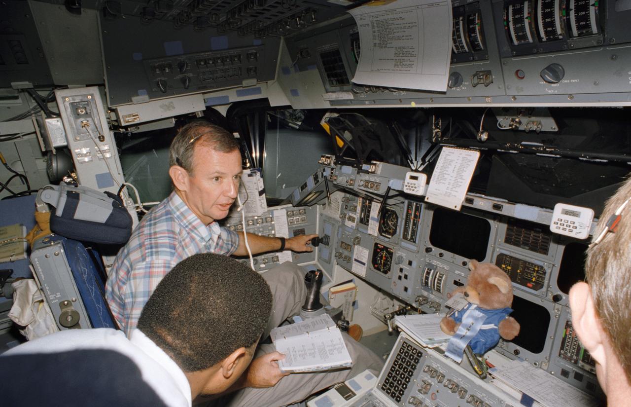 S95-12716 (May 1995) --- Astronauts Brian Duffy, in commander's seat, and Winston E. Scott discuss their scheduled flight aboard the Space Shuttle Endeavour. The two are on the flight deck of the Johnson Space Center's (JSC) fixed base Shuttle Mission Simulator (SMS). Duffy, mission commander, and Scott, mission specialist, will be joined for the winter flight by three other NASA astronauts and an international mission specialist representing NASDA.
