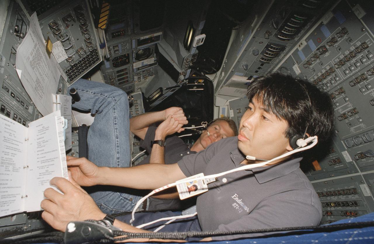 S95-12725 (May 1995) --- Astronaut Koichi Wakata, representing Japan's National Space Development Agency (NASDA) and assigned as mission specialist for the STS-72 mission, checks over a copy of the flight plan.  Wakata is on the flight deck of the fixed base Shuttle Mission Simulator (SMS) at the Johnson Space Center (JSC). In the background is astronaut Brent W. Jett, pilot. The two will join four NASA astronauts aboard Space Shuttle Endeavour for a scheduled nine-day mission, now set for the winter of this year.