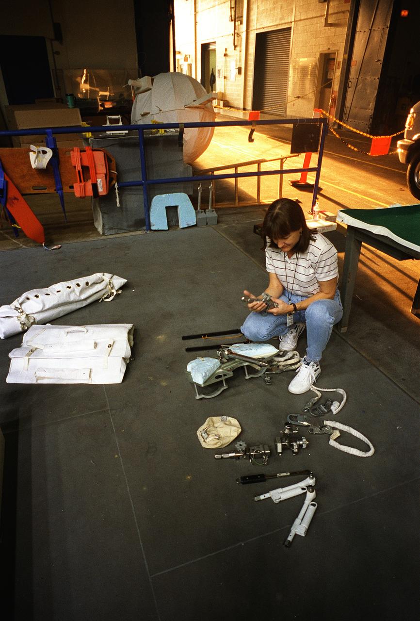 S95-21275 (September 1995) --- Astronaut Linda M. Godwin, mission specialist, checks training versions of tools to be used in a scheduled Extravehicular Activity (EVA) during the March mission.  Astronaut Michael R. (Rich) Clifford, mission specialist, who will join Godwin on the EVA, is out of frame.  The two checked out the hardware before donning training versions of the Extravehicular Mobility Unit (EMU) spacesuit in preparation for being submerged in a 25-feet deep pool at the Johnson Space Center's (JSC) Weightless Environment Training Facility (WET-F).