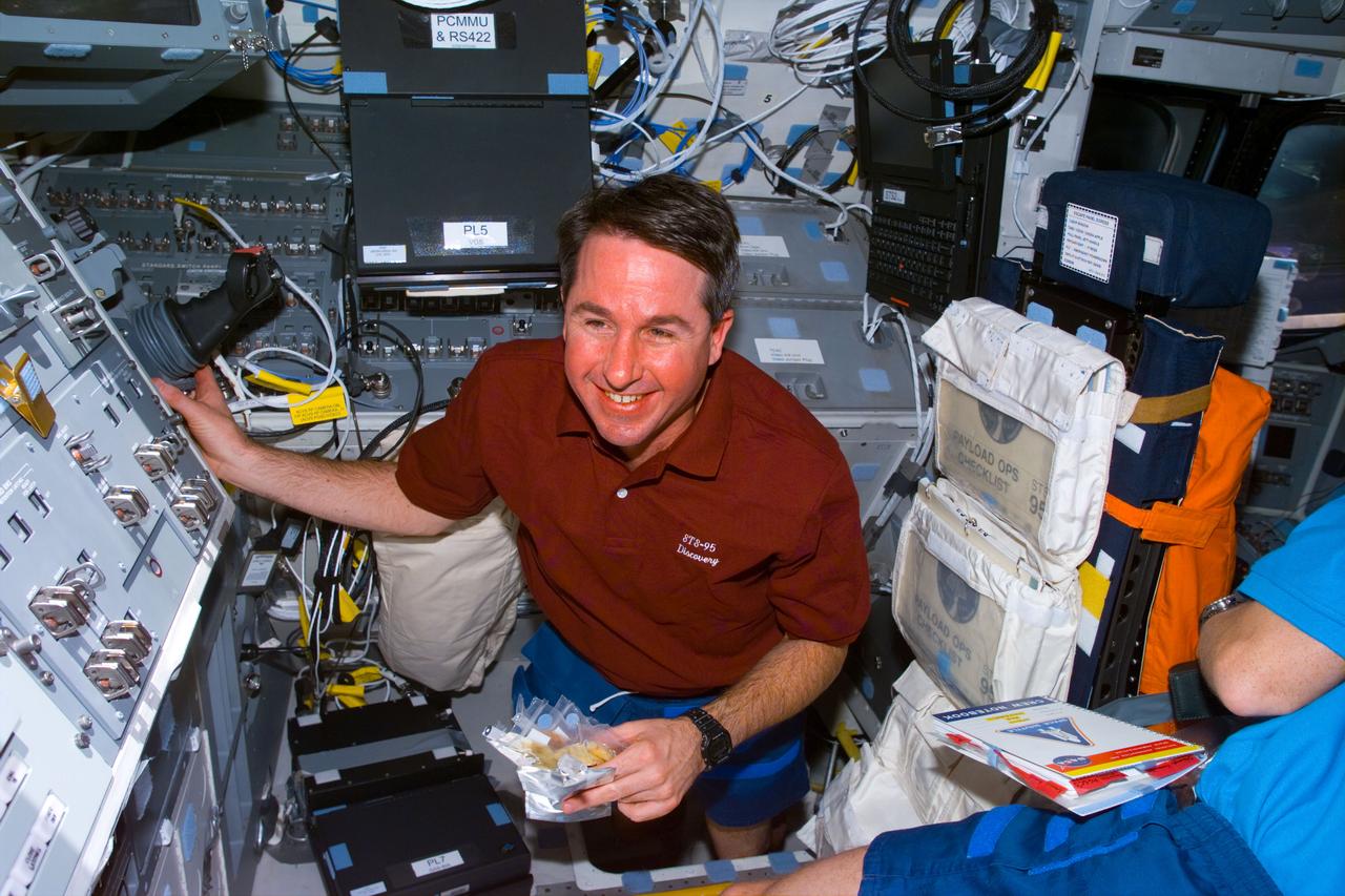STS095-E-5029 (10-29-98) --- Astronaut Stephen K. Robinson, mission specialist, on Discovery's aft flight deck. Astronaut Pedro Duque, representing the European Space Agency (ESA) is partially visible at right. The photo was taken at 11:32:09 GMT, Oct. 29.
