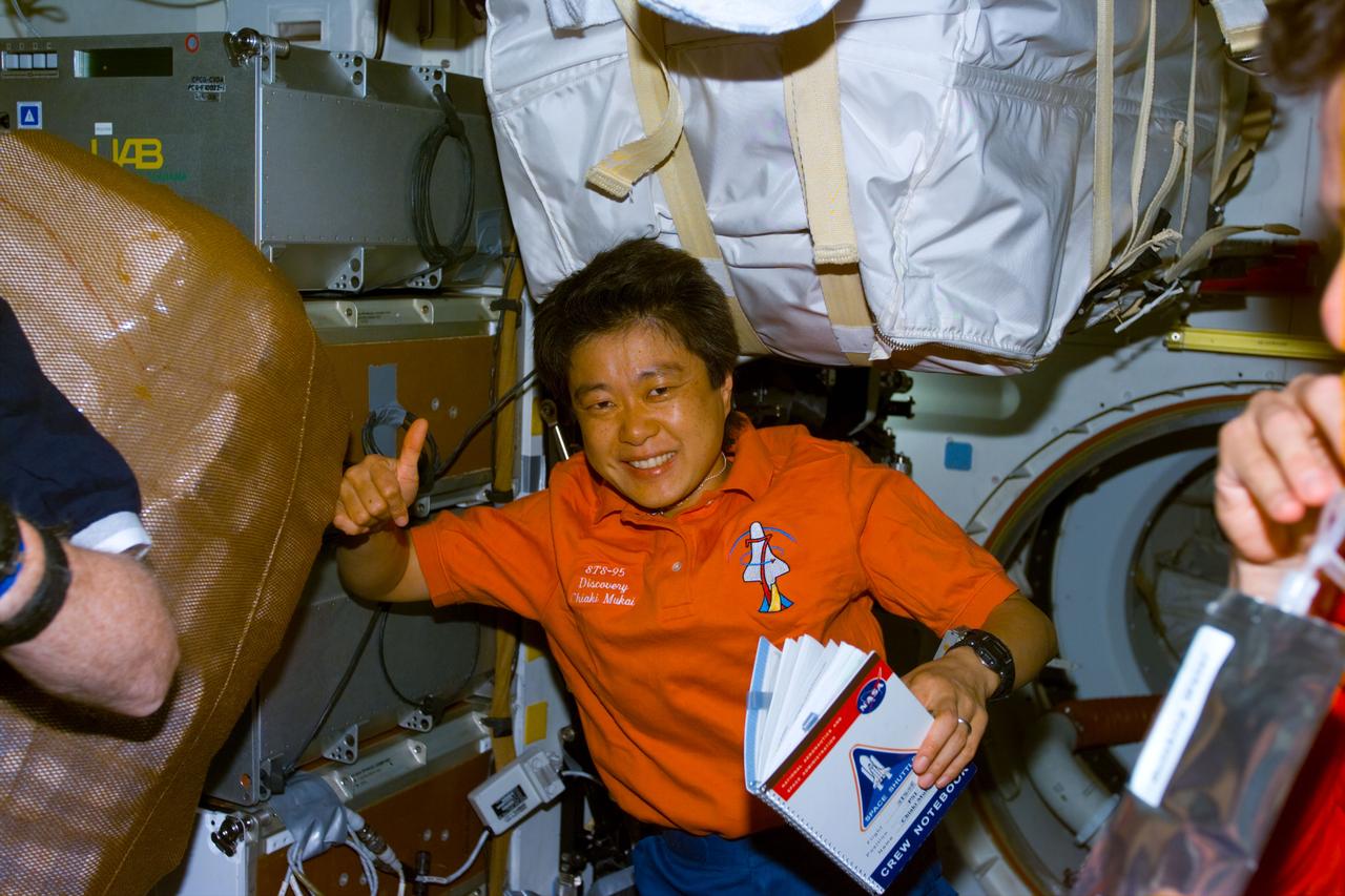 STS095-E-5037 (10-29-98) --- Holding a notebook filled with Flight Day 1 activity, payload specialist Chiaki Mukai gives an "all okay" signal. The photograph was taken with an electronic still camera (ESC) at 10:04:30 GMT, Oct. 29.