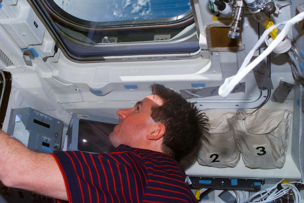 STS095-E-5065 (30 Oct. 1998) --- Astronaut Stephen K. Robinson, STS-95 mission specialist, looks toward Earth in this electronic still camera's (ESC) image of Flight Day two activity aboard the Space Shuttle Discovery. The scene was recorded on the aft flight deck at 12:02:11 GMT, Oct. 30.
