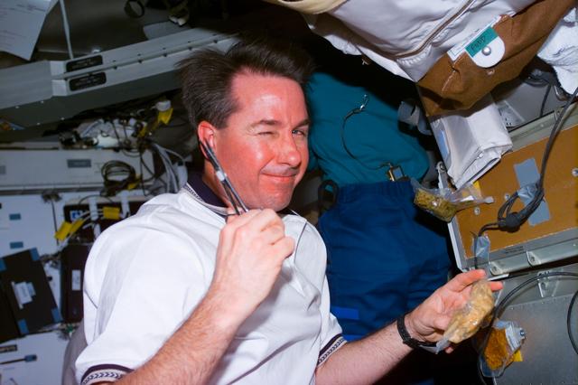 NASA image: Robinson on middeck preparing a meal