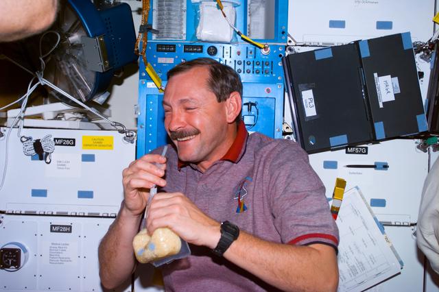 NASA image: Brown on middeck with drink packet