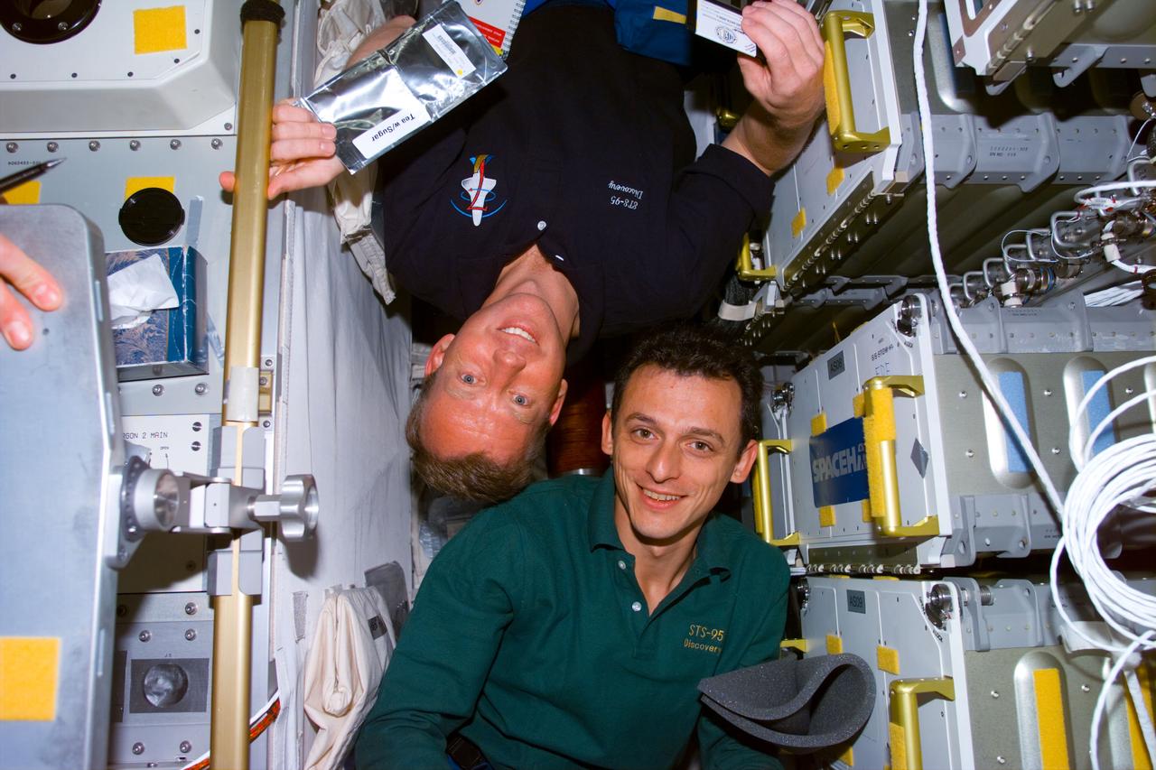 STS095-E-5221 (4 Nov. 1998) --- Astronauts Steven W. Lindsey (top) and Pedro Duque in Spacehab facility during Flight Day 6 activity. Lindsey, pilot, is making his second space flight on STS-95, while Duque, a mission specialist repreenting the European Space Agency (ESA), is the only first-time space flier on this mission. The photo was taken with an electronic still camera (ESC) at 03:01:38 GMT, Nov. 4.