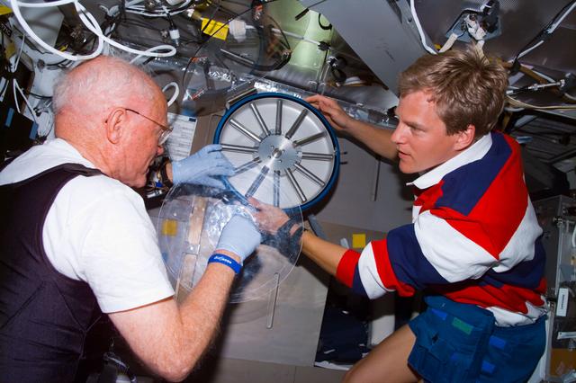 NASA image: Glenn and Parazynski prepare to put blood samples into centrifuge
