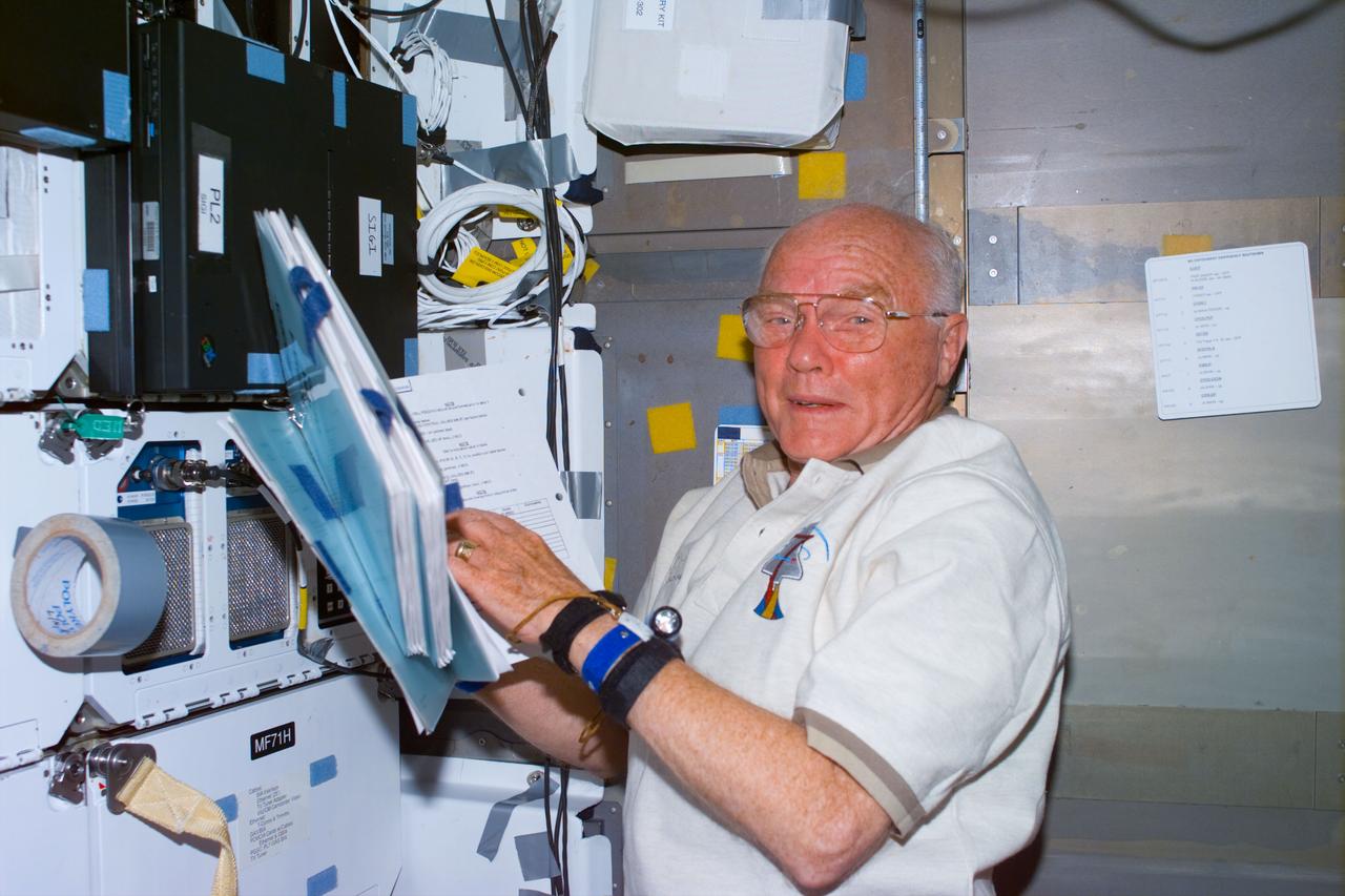 STS095-E-5258 (4 Nov. 1998) --- U.S. Sen. John H. Glenn Jr. (D.-Ohio), STS-95 payload specialist, checks over a notebook during Flight Day 7 activity aboard the Space Shuttle Discovery. The photo was taken with an electronic still camera (ESC) at 22:53:28 GMT, Nov. 4.
