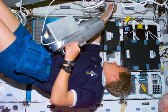 NASA image: Parazynski uses shuttle vacuum cleaner on middeck