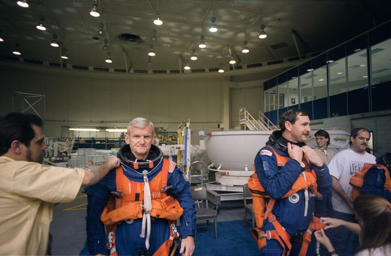 S96-08066 (April 1996) --- Left to right, astronauts John H. Casper, mission commander, and Curtis L. Brown, Jr., pilot, get help with the final touches of suit donning during emergency bailout training for STS-77 crew members in the Johnson Space Center?s (JSC) Weightless Environment Training Facility (WET-F).  Casper and Brown will join four other astronauts for nine days aboard the Space Shuttle Endeavour next month.