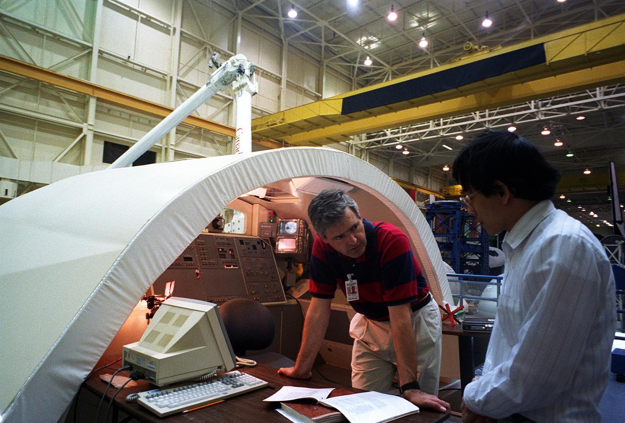 S96-08071 (April 1996) --- Crew trainer Viet Nguyen briefs Canadian astronaut Marc Garneau, mission specialist, on Remote Manipulation System (RMS) procedures during a training session in the Johnson Space Center's (JSC) Manipulator Development Facility (MDF).  Garneau will be making his second flight in space when he joins five NASA astronauts for nine days aboard the Space Shuttle Endeavour next month.