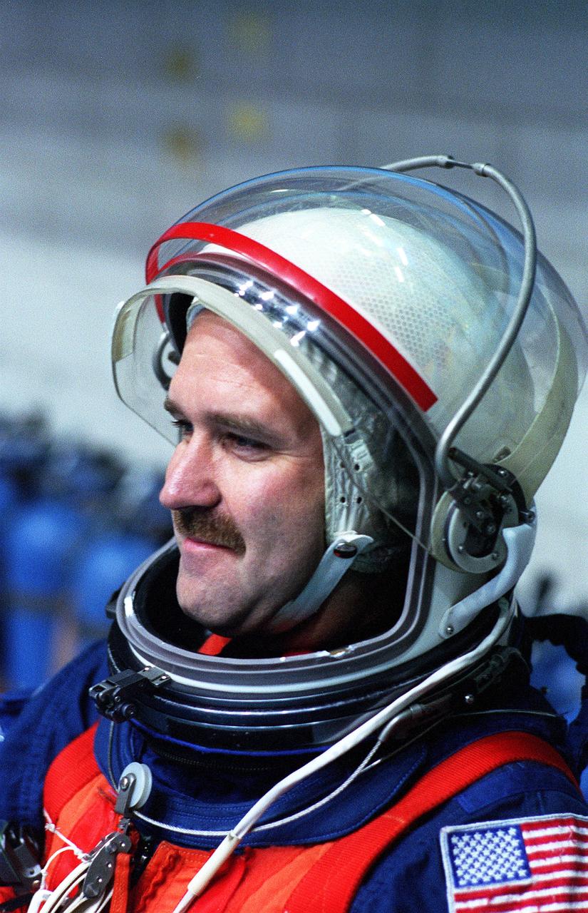 S96-15402 (26 Sept. 1996) --- In the Johnson Space Center's weightless environment training facility, astronaut John M. Grunsfeld, STS-81 mission specialist, prepares to simulate a parachute drop into water. Five STS-81 crewmates, out of frame, joined him for the bailout training exercises.