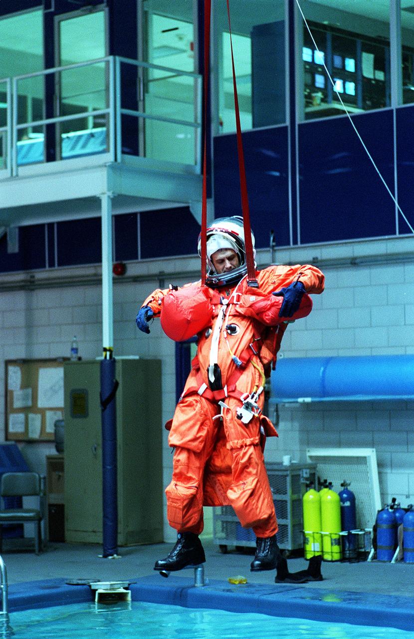 S96-15407 (26 Sept. 1996) --- In the Johnson Space Center's weightless environment training facility, astronaut Peter J.K. (Jeff) Wisoff, STS-81 mission specialist, simulates a parachute drop into water. Five STS-81 crewmates, out of frame, joined him for the bailout training exercises.