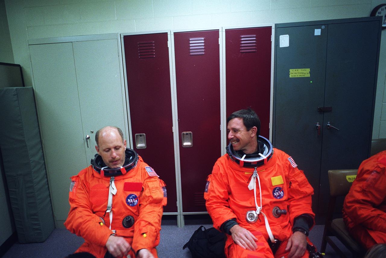 S96-18552 (30 Oct. 1996) --- Astronaut Kenneth D. Bowersox (left), STS-82 mission commander, chats with astronaut Scott J. Horowitz prior to an emergency bailout training session in JSC's systems integration facility.  Wearing training versions of the partial pressure launch and entry escape suit, Bowersox and his crew simulated an emergency ejection, using the escape pole system on the mid deck, as well as other phases of their scheduled February mission.