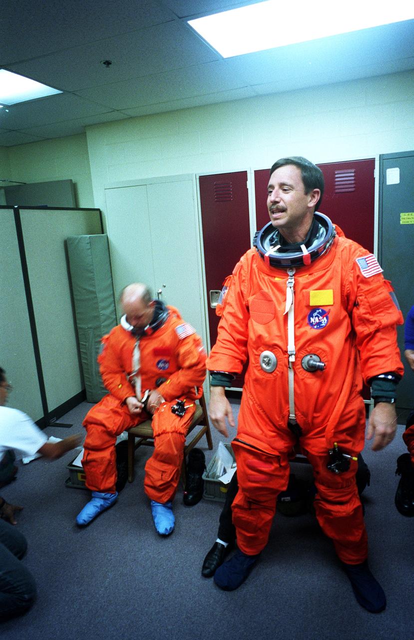 S96-18556 (30 Oct. 1996) --- Astronauts Scott J. Horowitz (standing) and Kenneth D. Bowersox wind up suit donning for a training session in JSC's systems integration facility.  Wearing training versions of the partial pressure launch and entry escape suit, the STS-82 pilot and mission commander joined their crewmates in simulating an emergency ejection, using an escape pole on the mid deck, as well as other phases of their scheduled February mission.