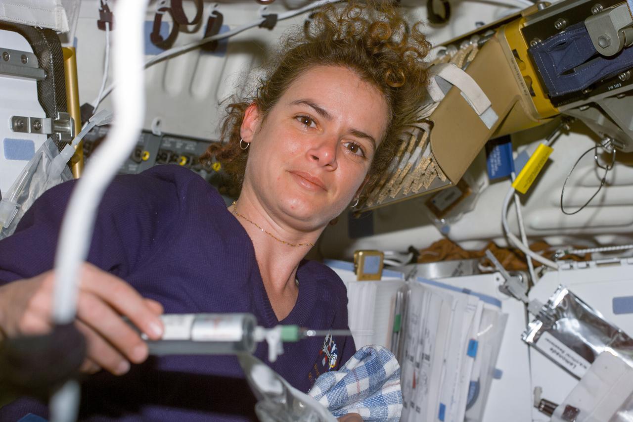 S96-E-5024 (29 May 1999) --- Astronaut Julie Payette, mission  specialist representing the Canadian Space Agency (CSA), holds a syringe during a busy fourth day in space for the Space Shuttle Discovery.  The image was recorded with an electronic still camera (ESC) at 06:14:52 GMT, May 29, 1999.