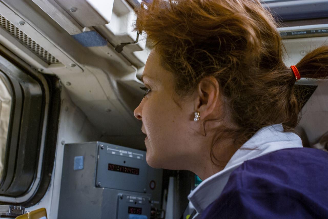 S96-E-5059 (29 May 1999) --- Astronaut Tamara Jernigan looks at the docked International Space Station (ISS) in Discovery's cargo bay.  The photo was taken at 04:37:30 GMT, May 29, 1999.