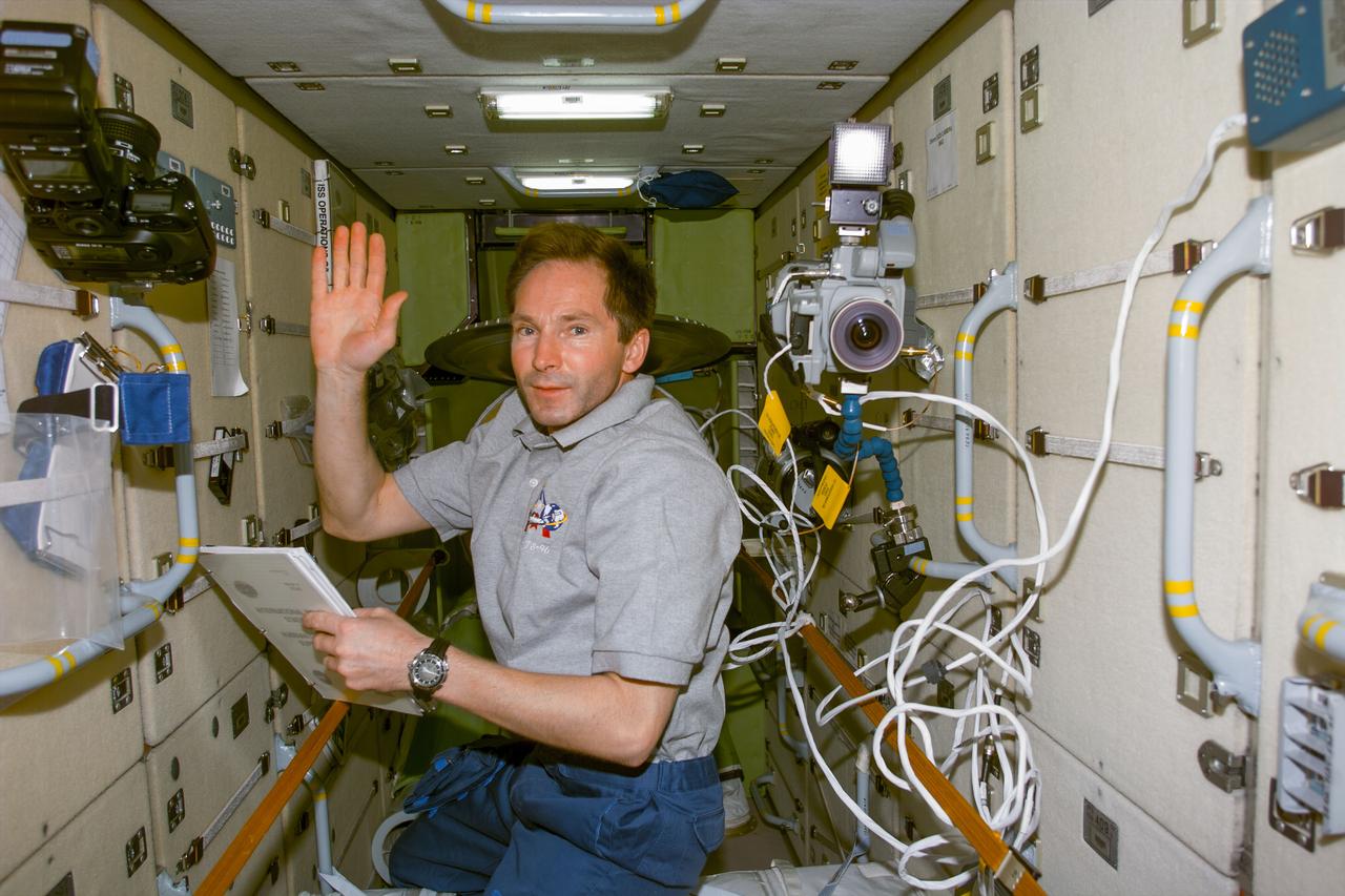 S96-E-5123 (1 June 1999) --- Cosmonaut Valery I. Tokarev waves at a crewmate during work in the Russian-built Zarya on Flight Day 6. The photo was recorded with an electronic still camera (ESC) at 07:47:59 GMT, June 1, 1999.