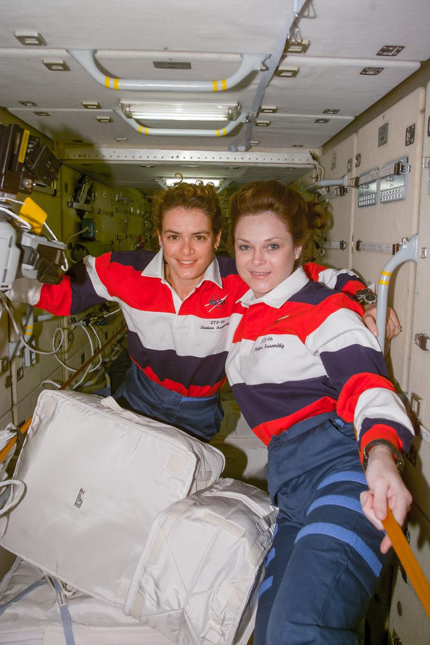 S96-E-5161 (2 June 1999) --- Astronauts Jule Payette (left) and Tamara E. Jernigan, mission specialists, participate in the final hours of tasks designed to prepare the   International Space Station (ISS) for  business.  Here, on  the Russian-built Zarya module, the two  are seen with a small part of the supplies brought up by the Space Shuttle Discovery.  The photo was taken with an electronic still camera (ESC) at 05:58:37 GMT, June 2, 1999.