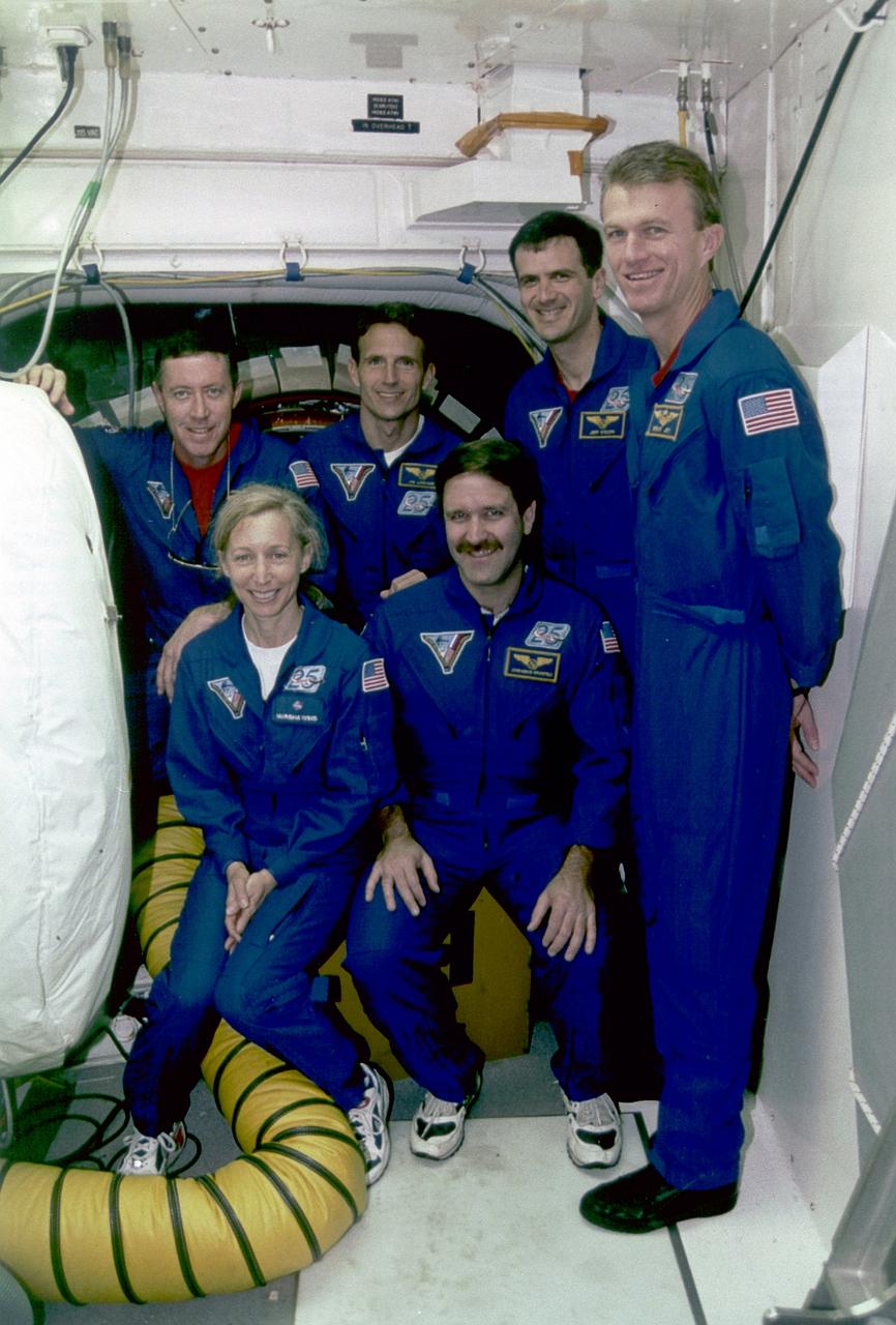 S97-00247 (15 Dec. 1996) --- The STS-81 mission flight crew poses outside the hatch of the space shuttle Atlantis at Launch Pad 39B during a Terminal Countdown Demonstration Test (TCDT). The TCDT represents a simulated final countdown rehearsal that ends just before main engine ignition. The actual launch is now scheduled for Jan. 12, 1997. Pictured (from the left) are astronauts Michael A. Baker, Marsha S. Ivins, Jerry M. Linenger, John M. Grunsfeld, Peter J.K. (Jeff) Wisoff, and Brent W. Jett Jr.