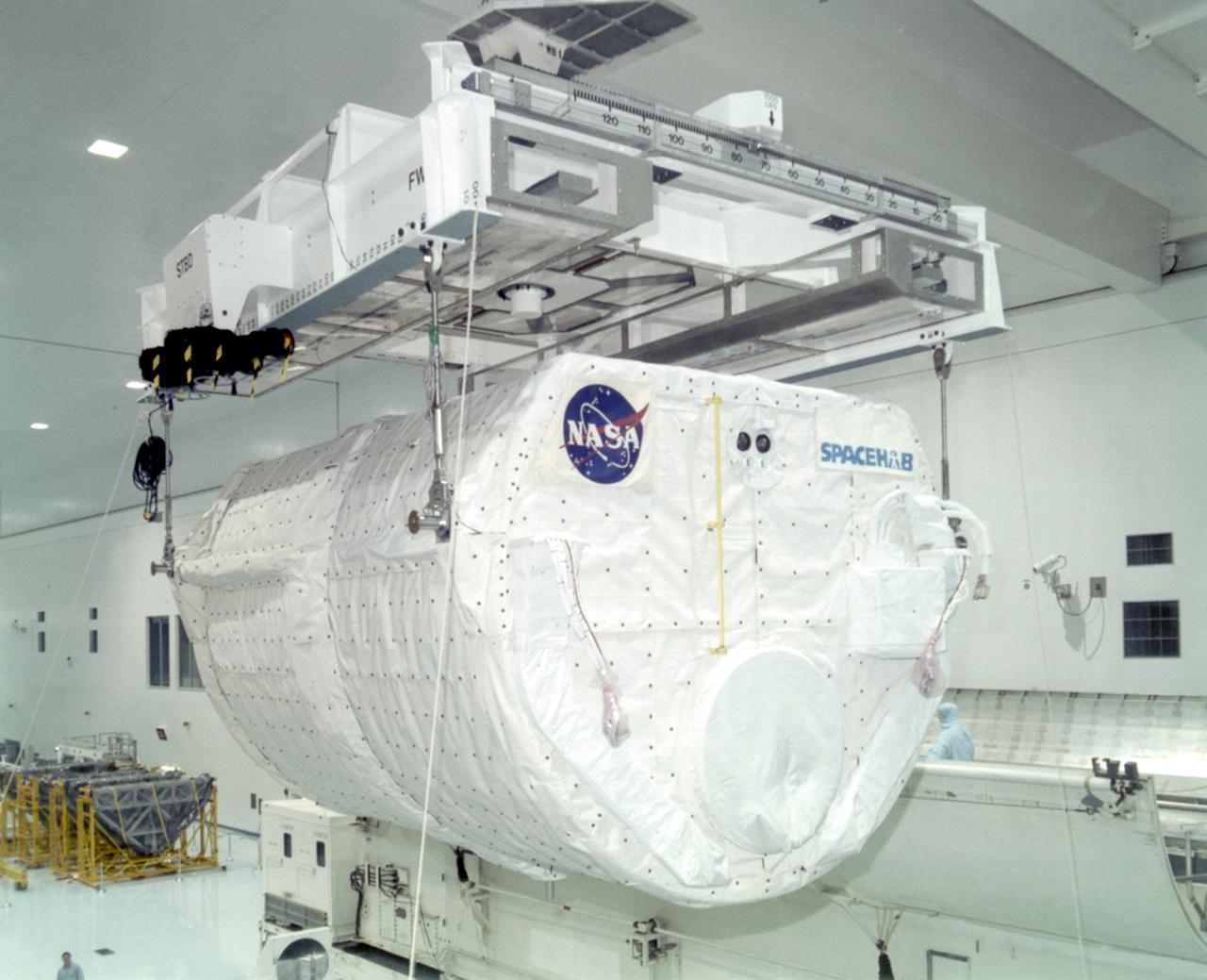 S97-00251 (5 Dec. 1996) --- The SPACEHAB-DM double module, scheduled to be used during STS-81 to transport Russian logistics material and supplies for the Mir-22 crew, is lowered into a payload canister in the Space Station Processing Facility at the Kennedy Space Center (KSC). The module will provide space for more than 2,000 pounds of hardware, food, water and other supplies which will be transferred by crewmembers into Mir during the 10-day mission. (Editor's Note: Following its installation into the canister, the module was transported on Jan. 12 to Launch Pad 39B and installed into the payload bay of the space shuttle Atlantis).