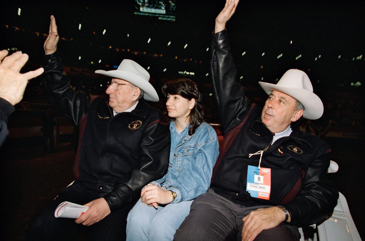 From left, Russian Space Agency Academician Vladimir Utkin, a TechTrans International interpreter and Johnson Space Center Director George Abbey wave from a vehicle in the Houston Livestock Show and Rodeo Grand Entry parade at the Astrodome. Utkin and Abbey wear cowboy hats. Appears in Space News Roundup Vol.36 No.9, February 28, 1997 issue.