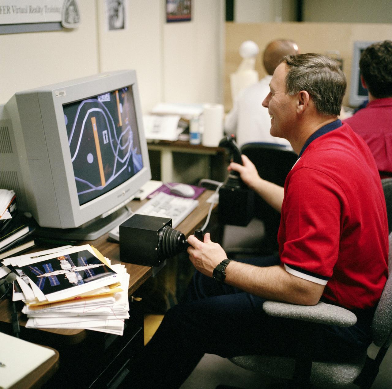 S98-05076 (8 Apr. 1998) --- Astronaut Jerry L. Ross, assigned as a mission specialist for the mission, uses special gear and software to train for his duties aboard the Space Shuttle Endeavour.  This type virtual reality training supplements practice for each of the assigned space-walking astronauts -- Ross and James H. Newman -- during which they wear a helmet and special gloves to look at computer displays simulating actual movements around the various locations on the early International Space Station (ISS) hardware with which they'll be working.  One of those elements will be the Functional Cargo Block (FGB), which will have been launched a couple of weeks prior to STS-88.  Once the FGB is captured using the Remote Manipulator System (RMS) of the Endeavour, astronaut Nancy J. Currie will maneuver the robot arm to dock the FGB to the conical mating adapter at the top of Node 1, to be carried in the Shuttle's cargo bay.  In ensuing days, three space walks by Ross and Newman will be performed to make power, data and utility connections between the two modules.  Currie also uses this same lab to train for her RMS controlling duties.