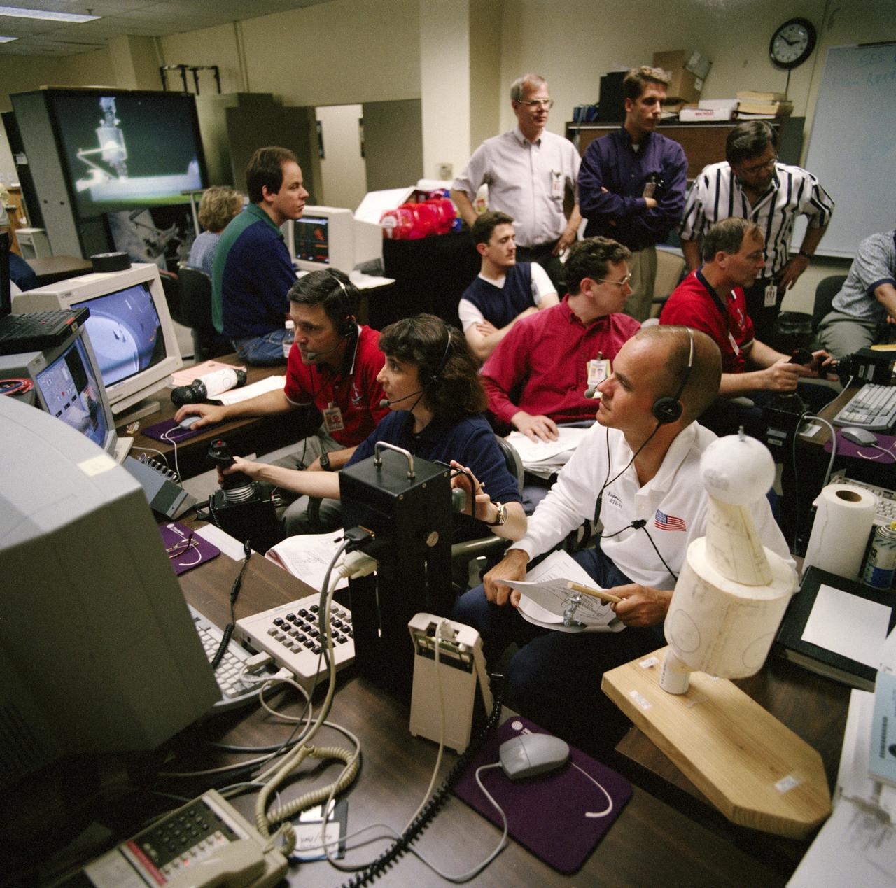 S98-05077 (8 Apr. 1998) --- With crew mates looking on, astronaut Nancy J. Currie, mission specialist, uses hardware in the virtual reality lab at the Johnson Space Center (JSC) to train for her duties aboard the Space Shuttle Endeavour.  She is flanked by astronaut Robert Cabana (left), commander; and Frederick W. Sturckow (right), pilot.  This type computer interface paired with virtual reality training hardware for the assigned space-walking astronauts -- Jerry L. Ross and James H. Newman -- helps to prepare the entire team for dealing with International Space Station (ISS) elements.  One of those elements will be the Functional Cargo Block (FGB), which will have been launched a couple of weeks prior to STS-88.  Once the FGB is captured using the Remote Manipulator System (RMS) of the Endeavour, Currie will maneuver the robot arm to dock the FGB to the conical mating adapter at the top of Node 1, to be carried in the Endeavour's cargo bay.  In ensuing days, three Extravehicular Activity?s (EVA) by Ross and Newman will be performed to make power, data and utility connections between the two modules.  Looking on is Scott A. Bleisath (behind Currie), with the EVA Systems Group at JSC.