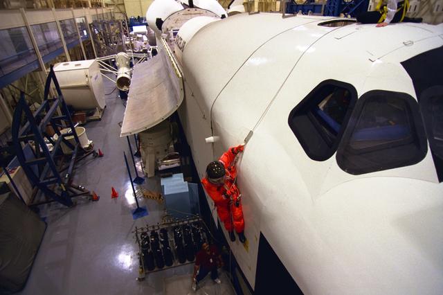 S98-06946 (28 April 1998) --- U.S. Sen. John H. Glenn Jr. (D.-Ohio), uses a device called a Sky genie to simulate rappelling from a troubled Space Shuttle during training at the Johnson Space Center (JSC). This  training mockup is called The full fuselage trainer (FFT). Glenn has been named as a payload specialist for STS-95, scheduled for launch later this year.  This exercise, in the systems integration facility at JSC, trains the crew members for procedures to follow in egressing a troubled shuttle on the ground.      Photo Credit:  Joe McNally, National Geographic, for NASA