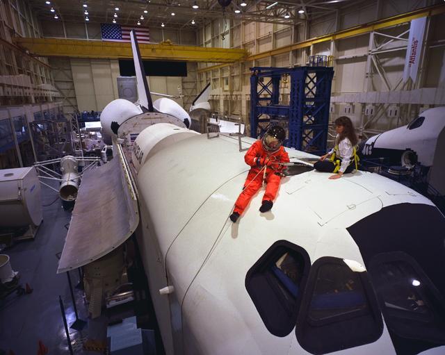 S98-06949 (28 April 1998) --- U.S. Sen. John H. Glenn Jr. (D.-Ohio), talks with crew trainer Sharon Jones prior to simulating procedures for egressing from a troubled space shuttle. This training mockup is called the full fuselage trainer (FFT). Glenn has been named as a payload specialist for STS-95, scheduled for launch later this year. Photo Credit: Joe McNally, National Geographic, for NASA