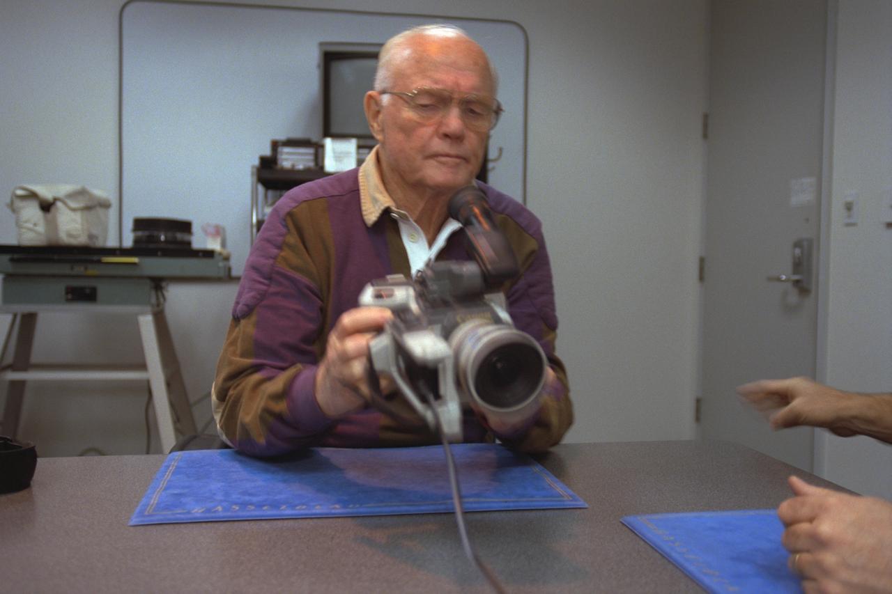 S98-08732 (9 April 1998) --- Holding a 35mm camera, U.S. Sen. John H. Glenn Jr. (D.-Ohio) gets a refresher course in photography from a JSC crew trainer (out of frame, right). The STS-95 payload specialist carried a 35mm camera on his historic MA-6 flight over 36 years ago. The photo was taken by Joe McNally, National Geographic, for NASA.