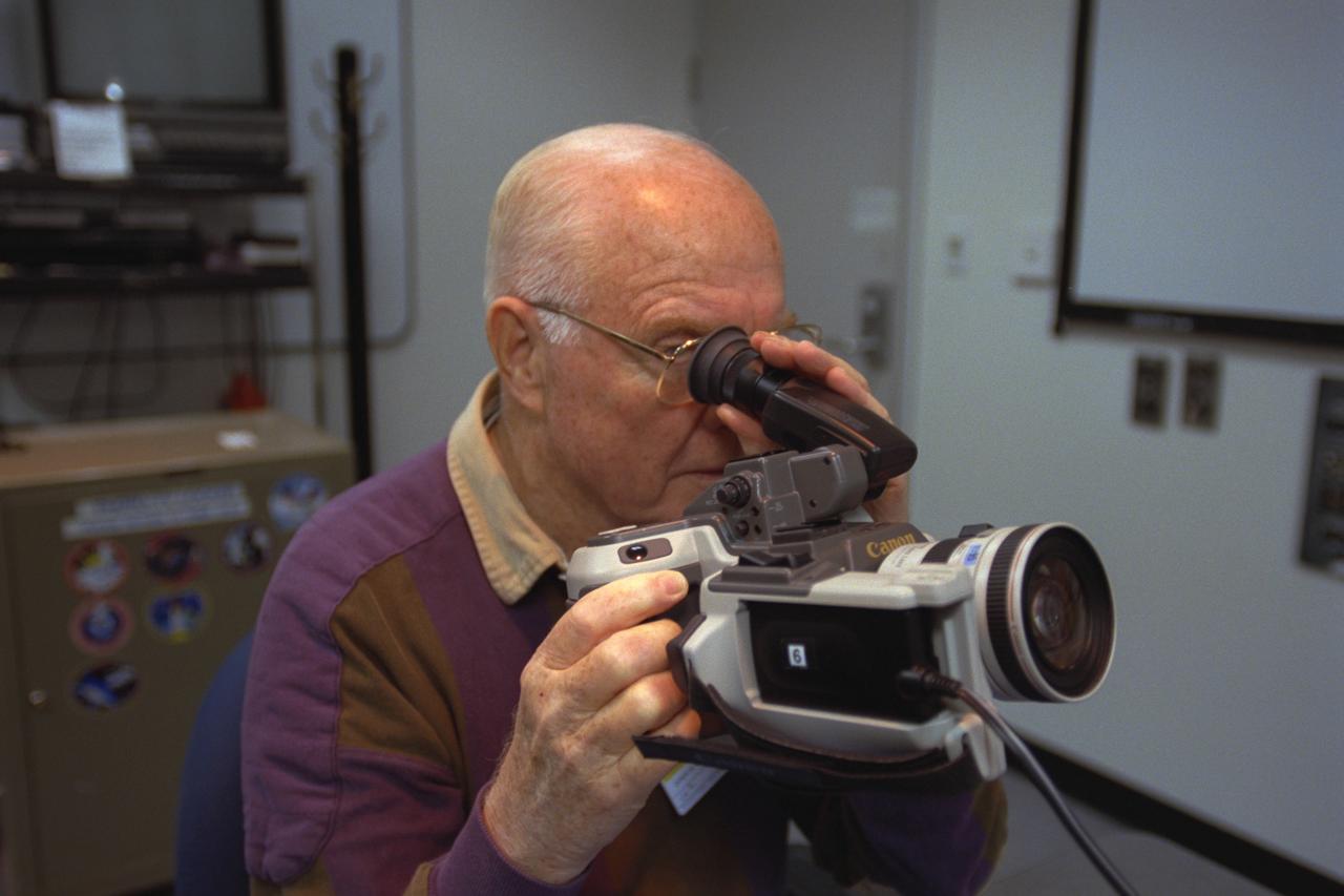 S98-08733 (9 April 1998) --- Looking through the view finder on a camera, U.S. Sen. John H. Glenn Jr. (D.-Ohio) gets a refresher course in photography from a JSC crew trainer (out of frame, right). The STS-95 payload specialist carried a 35mm camera on his historic MA-6 flight over 36 years ago. The photo was taken by Joe McNally, National Geographic, for NASA.